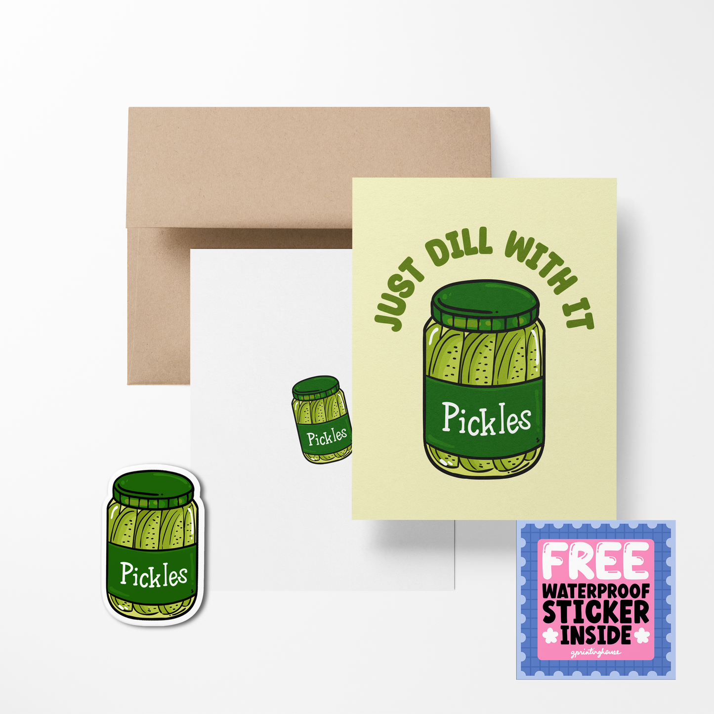 A greeting card with an illustration of a pickle jar, titled 'Just Dill With It', accompanied by a brown envelope and a free waterproof vinyl sticker.