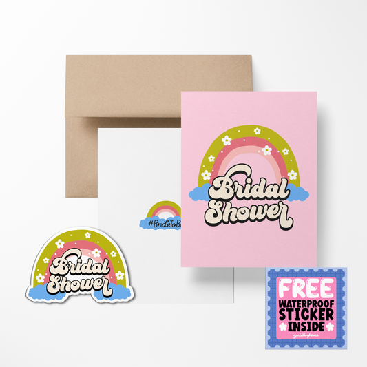 A bridal shower greeting card with a colorful design, including a rainbow and floral elements, and the text 'Bridal Shower'. Accompanied by a waterproof sticker which matches the card, both placed on a beige surface.