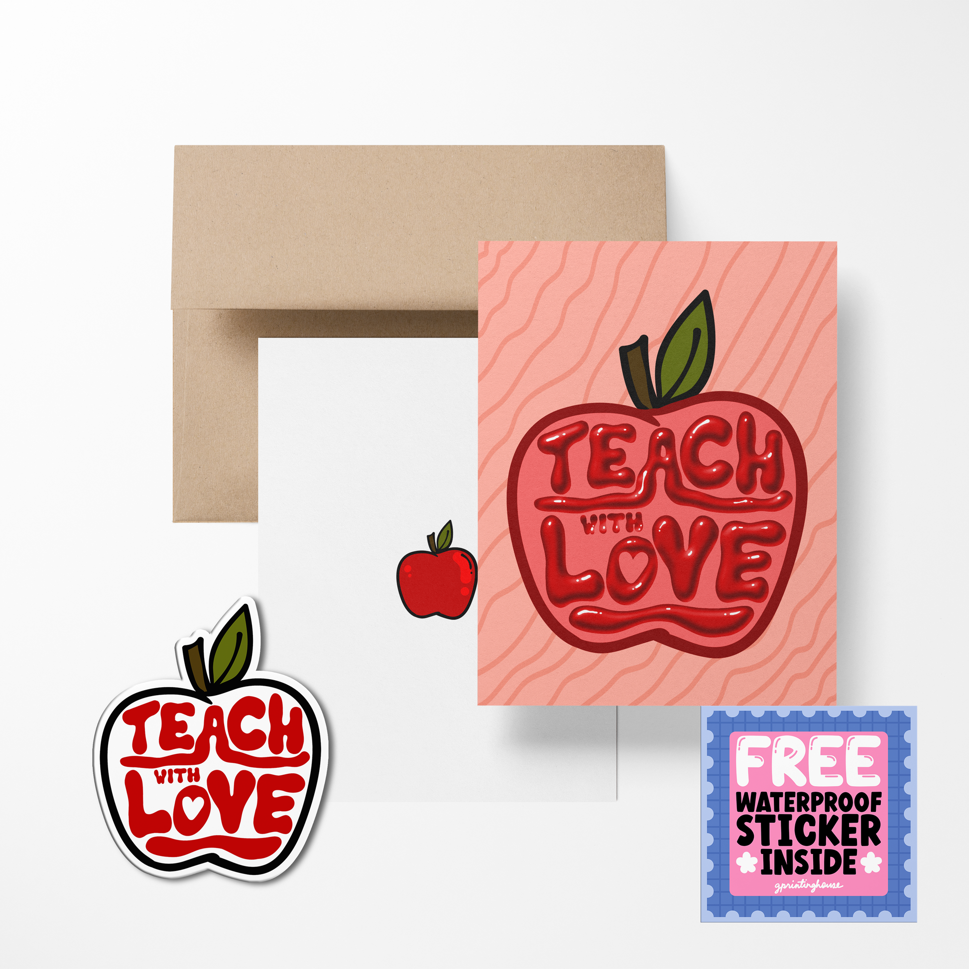 A greeting card with 'TEACH WITH LOVE' text in the shape of an apple, accompanied by a sticker with the same design. A brown envelope is also shown.