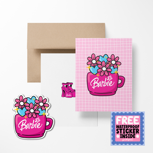 A greeting card featuring a cartoon image of a pink cup with 'Barbie' written on it and colorful flowers. Accompanied by a brown envelope and a free waterproof vinyl sticker.