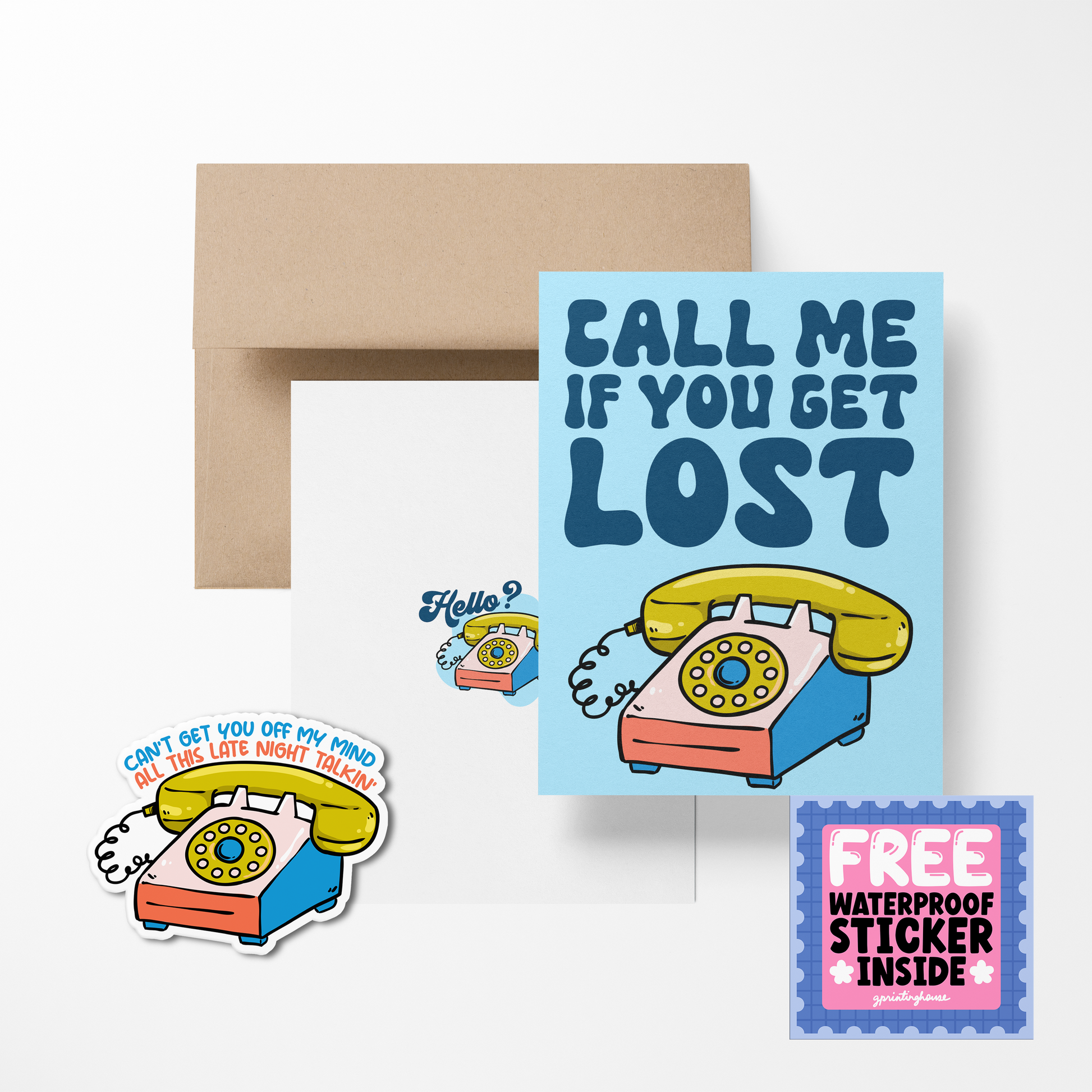 A greeting card with a playful telephone design and the text 'CALL ME IF YOU GET LOST', accompanied by a sticker and envelope.
