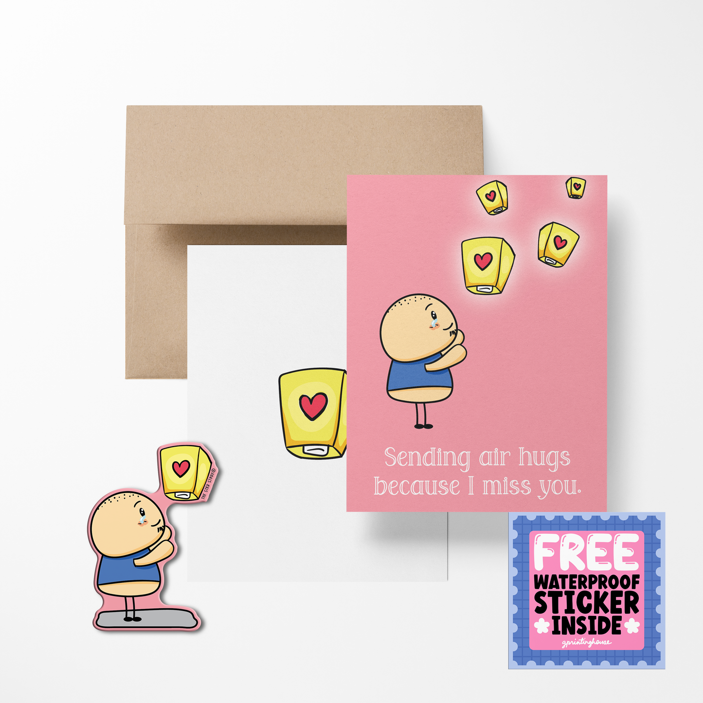A greeting card with a cartoon character sending air hugs, with a sticker that matches the card, and a kraft paper envelope.