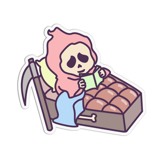 A cartoon die-cut sticker showing a skeleton character in a pink hood sitting in bed reading a green book, with a scythe and a box of brown round pastries on a white background.