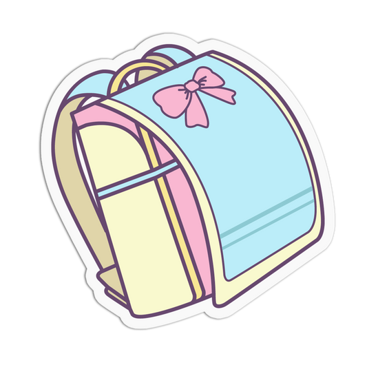 A die-cut sticker featuring a cute, pastel-colored school backpack illustration. The backpack has a light blue front panel with a pink bow, cream-colored side panels, and purple outlines, all set against a plain white background.