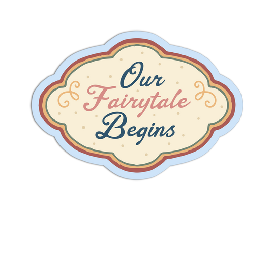 A decorative cloud-shaped sign or sticker with the phrase “Our Fairytale Begins” in stylized script. The design has a cream center, layered pastel outlines in blue, green, orange, and red, and small dotted details, shown on a plain white background.