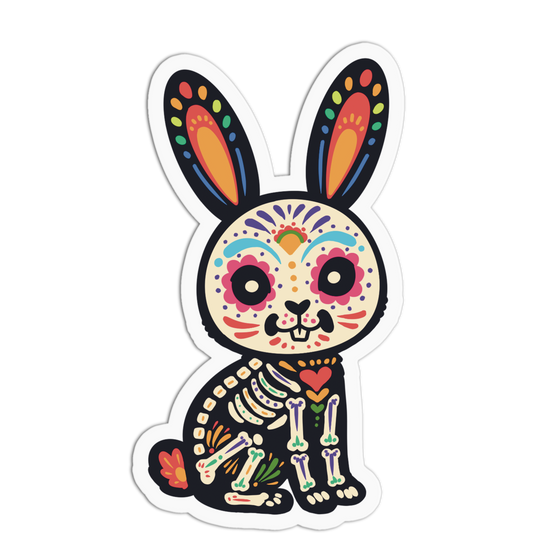 A die-cut vinyl sticker featuring a stylized cartoon rabbit in a colorful Day of the Dead sugar skull design, shown on a plain white background.