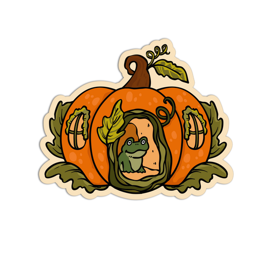 A die-cut sticker featuring an orange pumpkin with carved windows and a green frog peeking out from behind a vine, shown on a plain white background.
