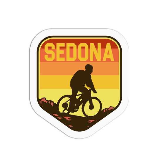 Sticker with 'SEDONA' text and a silhouette of a person on a bike against a sunset background.